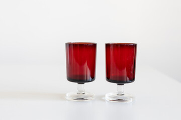 Two seventies style red glass liquor glasses isolated on white background