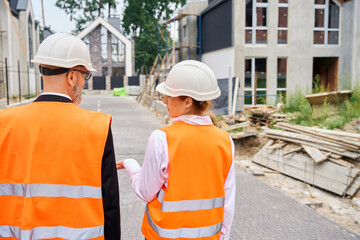 Building inspector talking to contractor during development site inspection