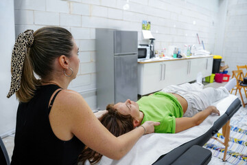 a masseuse performing a body care treatment on a female worker at the workplace
