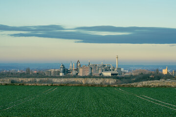 Fototapeta premium Concrete factory in a rural area in the sunset and copy space