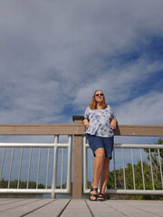 senior adult woman standing beside bridge railing