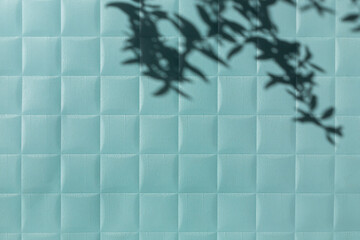 Blue paper checkered texture background with leaves shadows. Copy space
