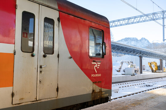 PolRegio train at Zakopane railway station platform, on a cold, snowy winter day. Polish regional rail operator wagon. Tatra Mountains Giewont in background on January 10, 2024 in Zakopane, Poland.