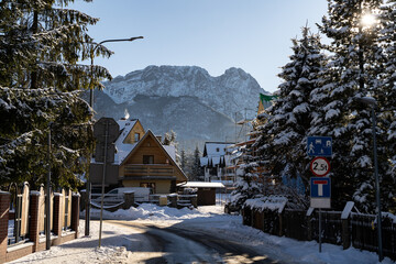 Giewont mountain massif, peak in the Tatra Mountains range, seen from Zakopane town, Poland. Part of Tatra National Park. Scenic landscape, iconic sleeping knight silhouette covered with winter snow. - obrazy, fototapety, plakaty
