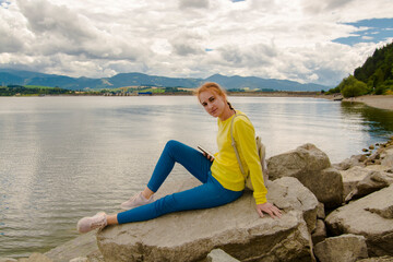 Fototapeta na wymiar Young woman and stones at Liptovska mara in Slovakia
