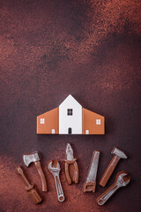 Repair or home improvement tools and a house model on a plain background