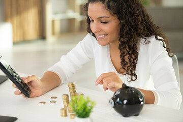 woman using calculator to compute coin saving