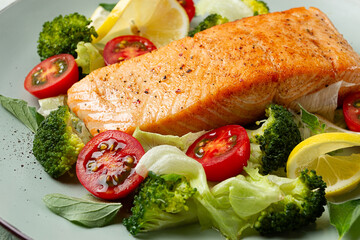 Fototapeta na wymiar grilled salmon fillet, with vegetables, broccoli, cherry, iceberg lettuce, spices and herbs, homemade, no people,
