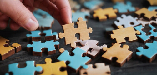 Wooden jigsaw puzzle pieces on dark wooden table background - obrazy, fototapety, plakaty