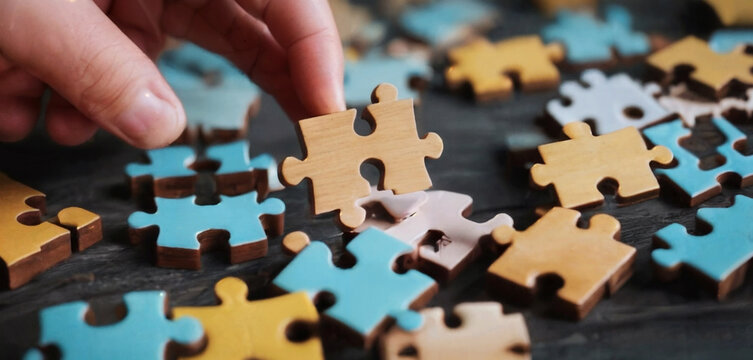 Wooden jigsaw puzzle pieces on dark wooden table background