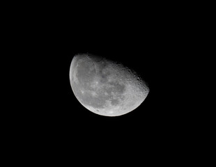 half waxing gibbous moon on night sky