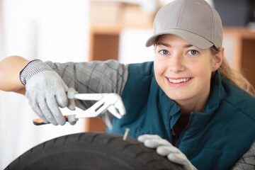 female auto repair mechanic repairing tyre