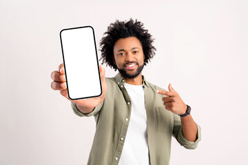 Positive confident man pointing at smartphone with white empty display, bragging with application....