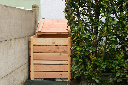 Nouveau composteur en bois vide au fond du jardin
