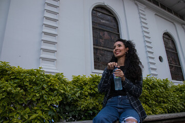 latin young woman drinking water on a hot day