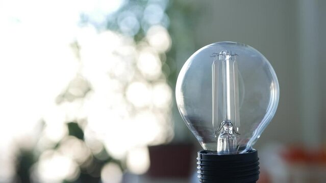 Blurred Shooting with a Person Powering Off the Led Light Bulb in a Room Using Smartphone App. Low Energy Consumption Concept with Led Lighting Technology. Powering Off the Light in a Room. 