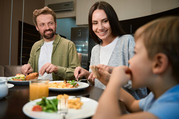 Couple looking at their son with smiles while having festive breakfast in hotel