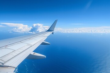 Airplane wing against ocean and blue sky