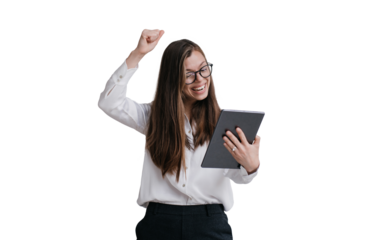 Expressive young brunette businesswoman in glasses, white shirt and black pants holding tablet making video call rising fist up against transparent background, celebrating great deal, laughing