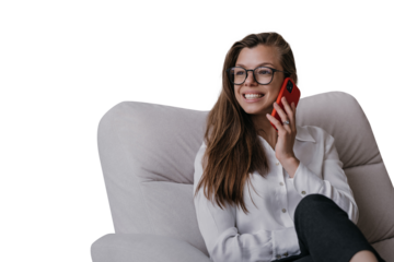 Cheerful businesswoman in glasses talking by cell phone sitting in chair smiling with surprised face against transparent background. Successful businesswoman gets great news