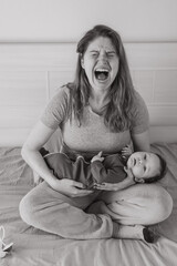Vertical photo. A woman holds a child in her arms and cries. Postpartum depression. 