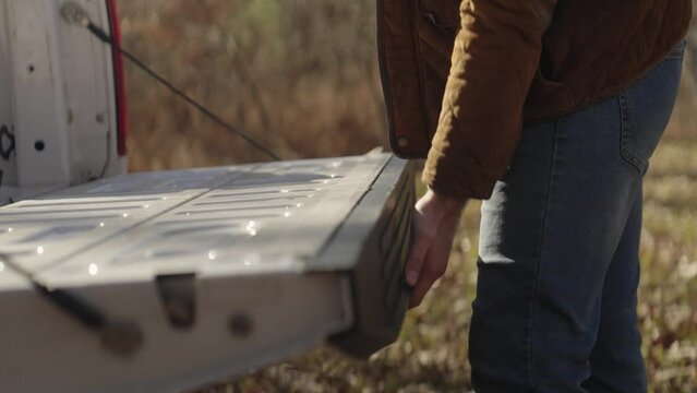 Man unloading bricks from a pickup truck and building an outdoor fire pit