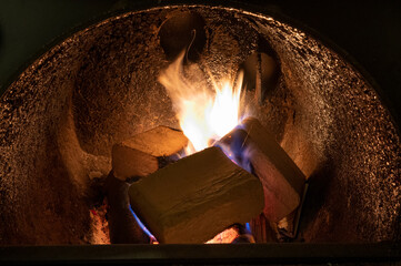 Wood briquettes (ruf type), made of beech and oak burning inside the wood fuel boiler. Alternative fuel, eco fuel, bio fuel.