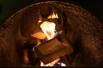 Wood briquettes (ruf type), made of beech and oak burning inside the wood fuel boiler. Alternative fuel, eco fuel, bio fuel.