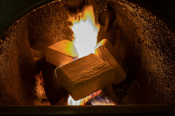 Wood briquettes (ruf type), made of beech and oak burning inside the wood fuel boiler. Alternative...