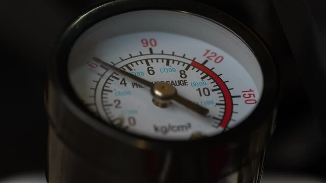 The pressure gauge needle moves around the dial and measures the variable pressure in the system. Air pressure gauge in the air pump, close up