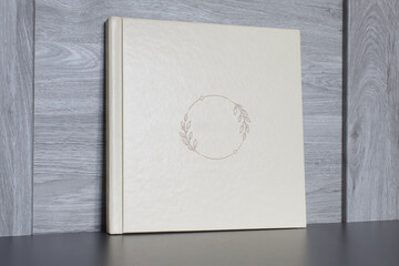 beige photo album with empty cover on wooden background with copy space for text. white photo book...