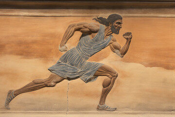 Bas-relief sculpture of a sprinter from the ancient Olympic Games. - obrazy, fototapety, plakaty