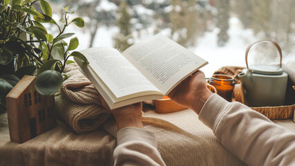 Girl holding a book in her hands, cozy morning - obrazy, fototapety, plakaty