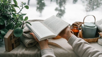 Girl holding a book in her hands, cozy morning