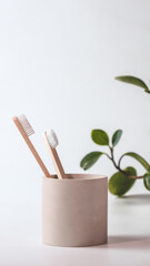 Bamboo toothbrushes in a stylish concrete glass on a white background