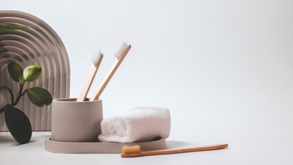 Bamboo toothbrushes in a stylish concrete glass on a white background