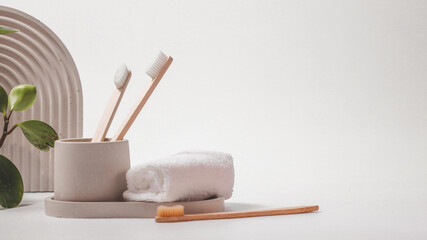 Bamboo toothbrushes in a stylish concrete glass on a white background