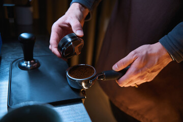 Barista leveling ground coffee in the portafilter