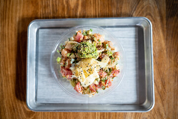 delicious top view of poke bowl with ginger avocado tuna salmon sesame seeds and much more at a fine dining hawaiian restaurant
