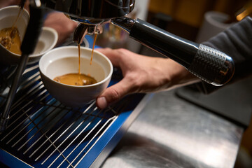Barista pouring espresso from coffee machine