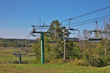 Chairlifts at ski resort in fall with no snow and lots of grass