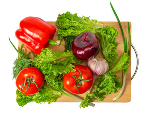 Vegetable still life. Tomatoes, garlic, onions, peppers, greens on kitchen board. Vegetarian food.