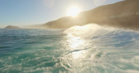 Aerial FPV drone footage of serene ocean waves and a majestic mountain landscape at sunrise, showcasing nature's beauty in dynamic, cinematic style - Powered by Adobe