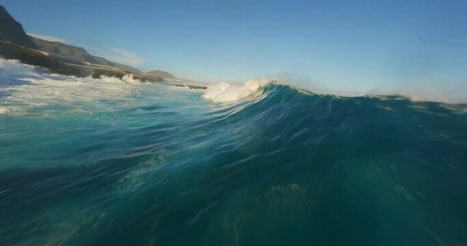 Aerial FPV drone footage of serene ocean waves and a majestic mountain landscape at sunrise, showcasing nature's beauty in dynamic, cinematic style