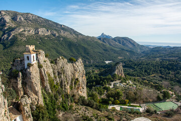 View of the medieval Guadalest castle  with a part of the fortifications in the tourist town of...