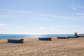 Barcas en la arena de la playa de Fuengirola en España con el agua del mediterráneo y el horizonte al fondo
