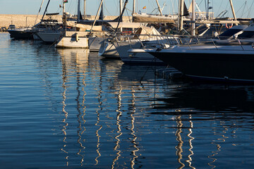 Puerto deportivo de Fuengirola Málaga,España, con barcos veleros atracados en el muelle y reflejados en el mar