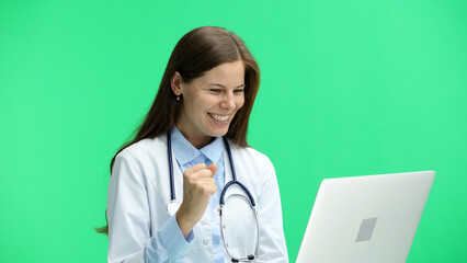 Female doctor, close-up, on a green background, with a laptop