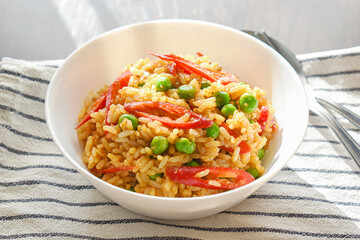 Spicy curry fried rice with sliced red chilli pepper and green peas. Healthy and dietary food. 