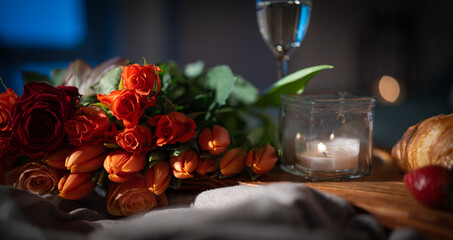 Breakfast with red roses and champagne on bed. Romantic background for valentins day ore mothers day.